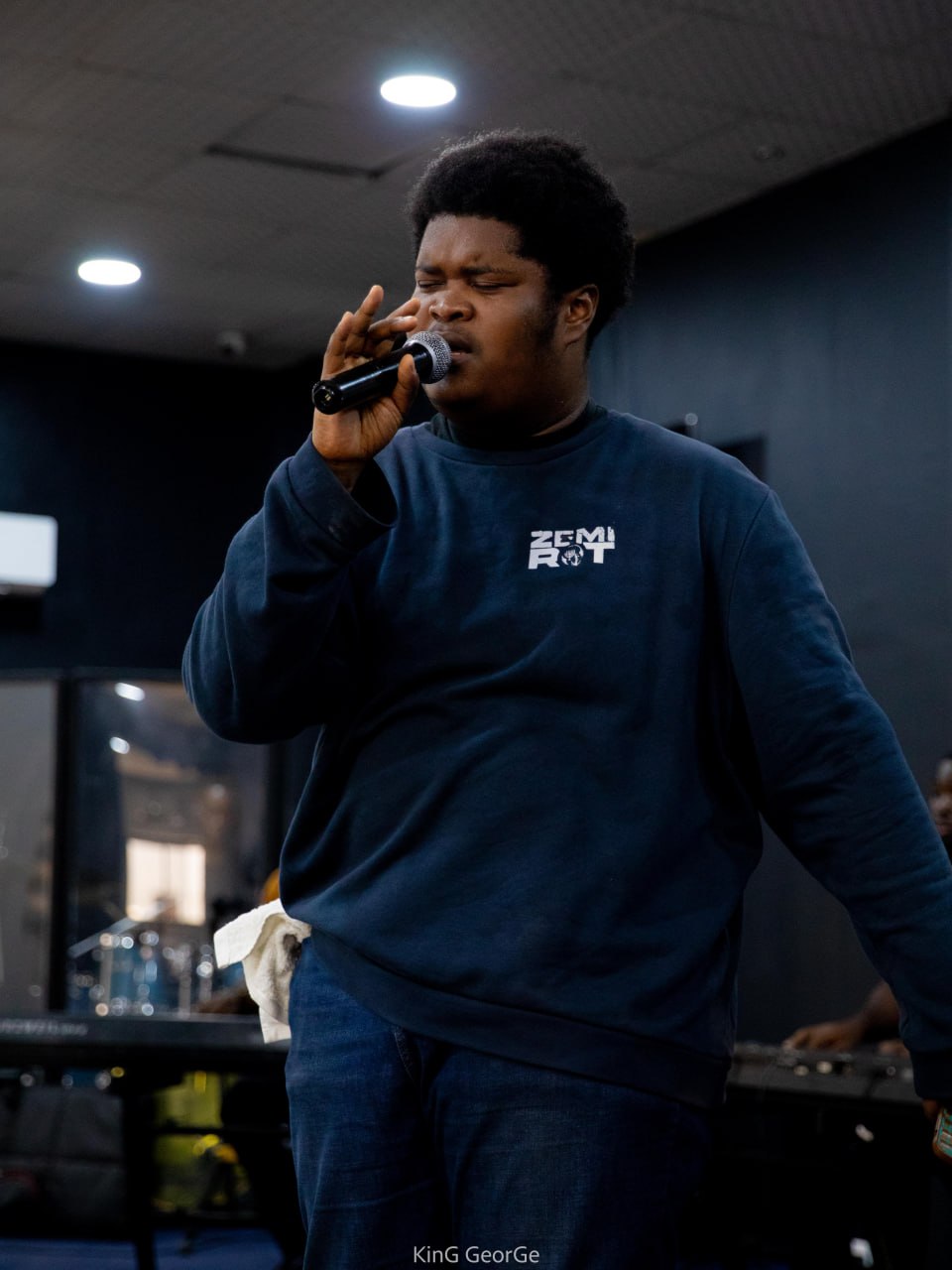 A Kings & Priests participant stretches their arms in motion before a green backdrop, embodying freedom and praise.