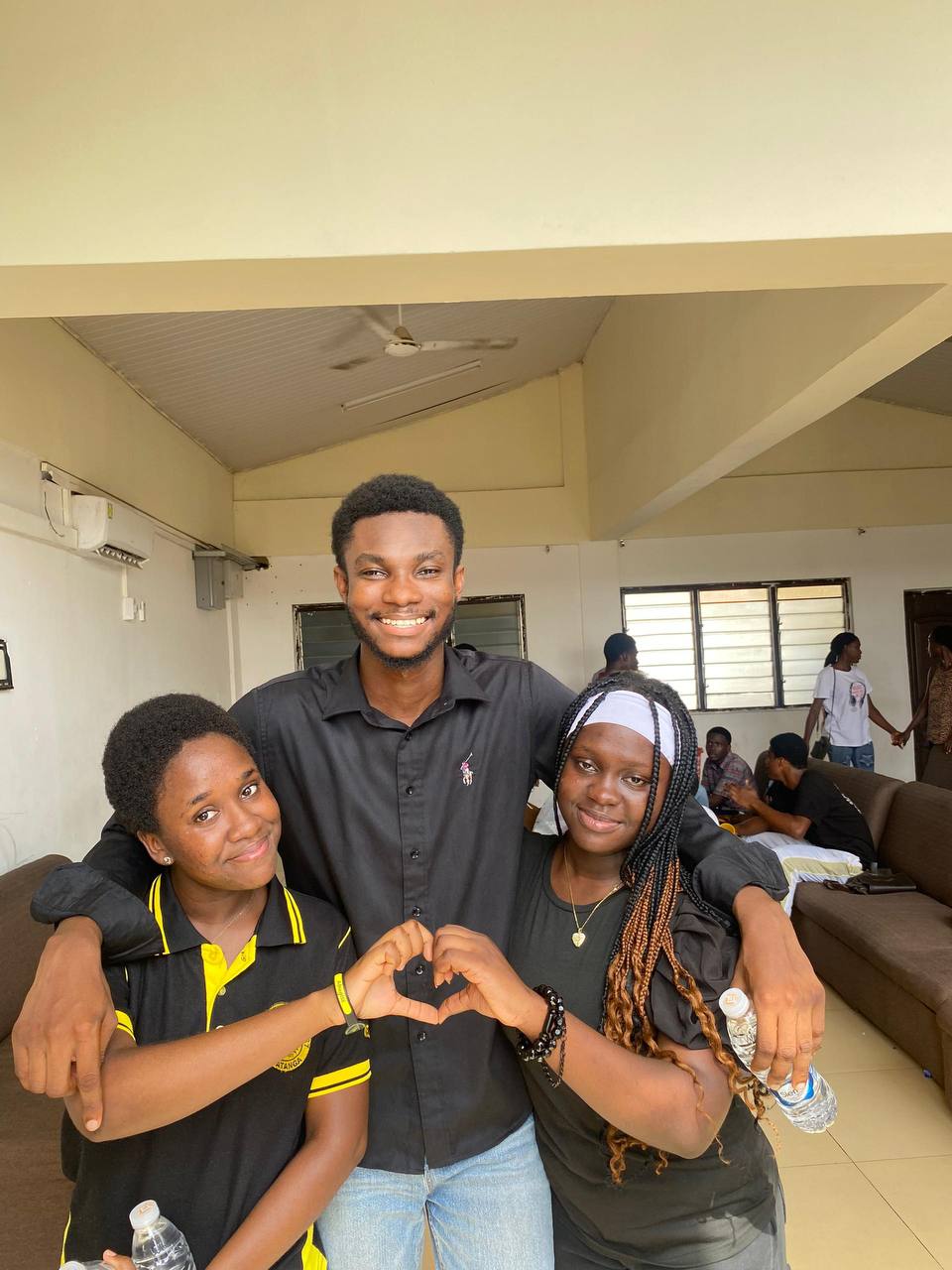 Thirteen Kings & Priests community members gather around a bench at Newtown Station, smiling in front of a train and a sign reading “Newtown.”