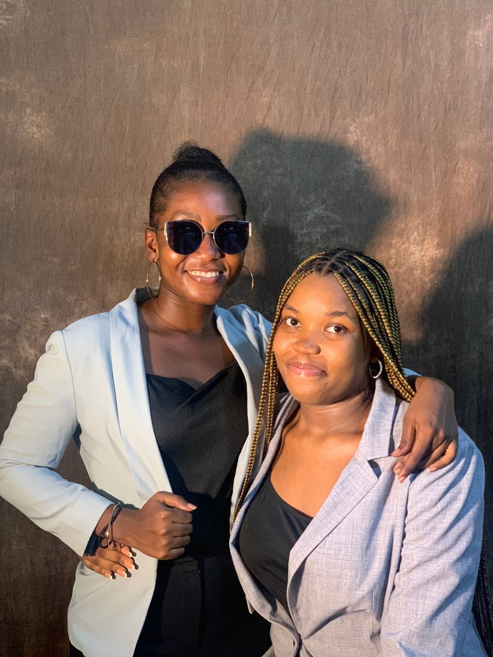 Kings & Priests friends smile together outdoors during an evening gathering.