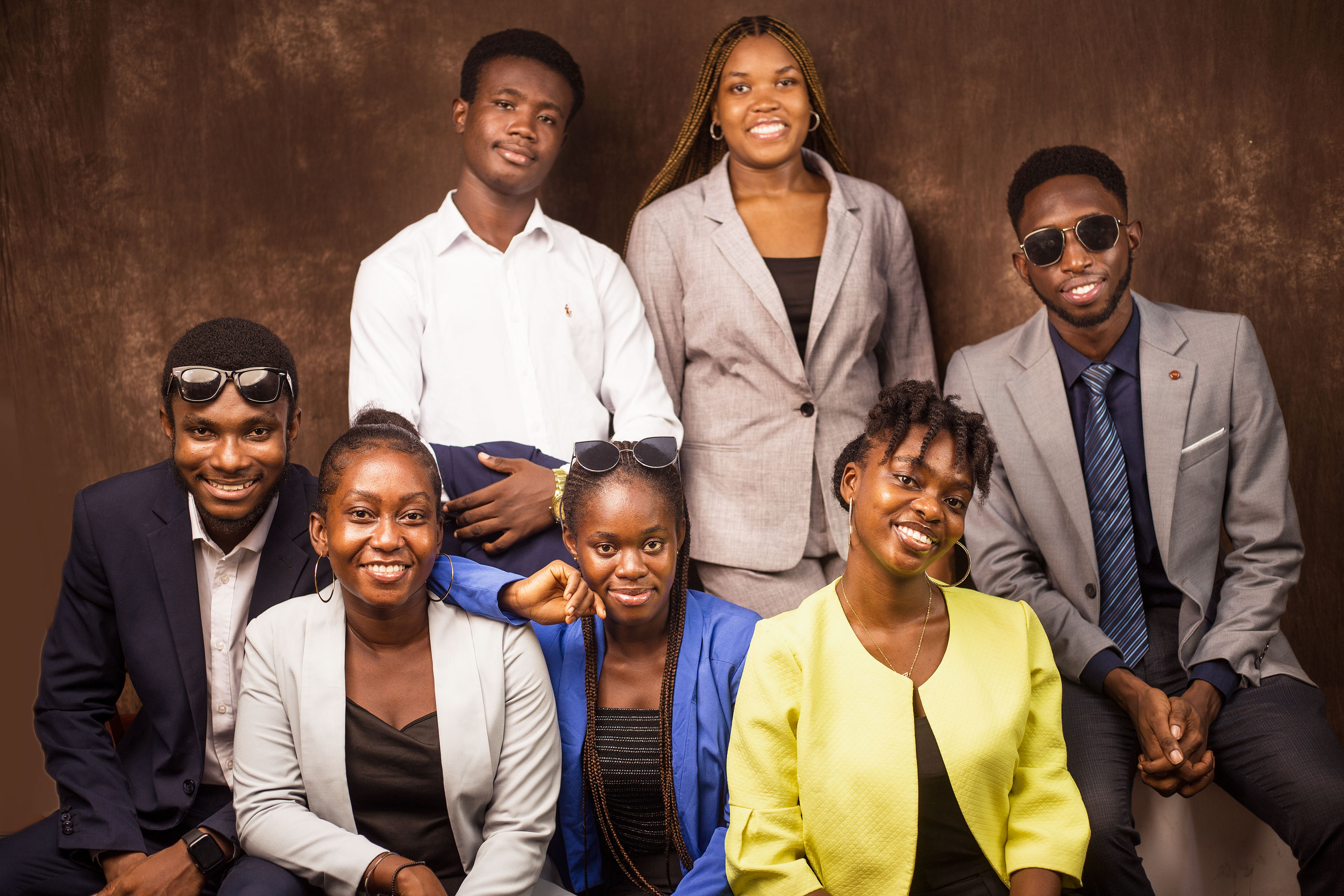 A large Kings & Priests cohort leans together in a studio group portrait around a hand-painted “HISSS 2024” sign.